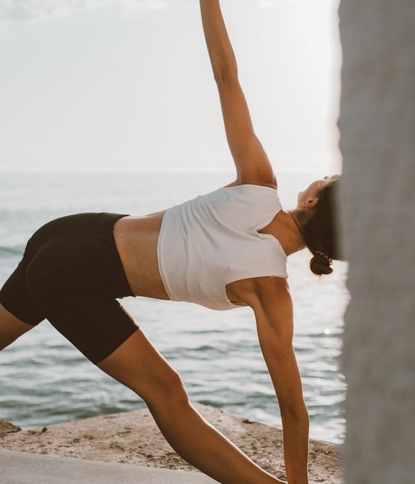 Person stretching outdoors at sunrise, feeling energized and flexible.